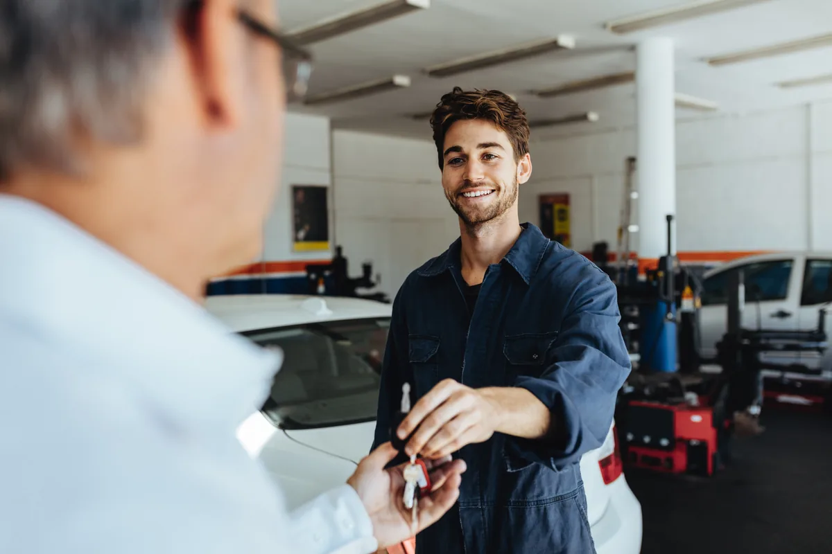 Technician handing car keys back to a customer after a service