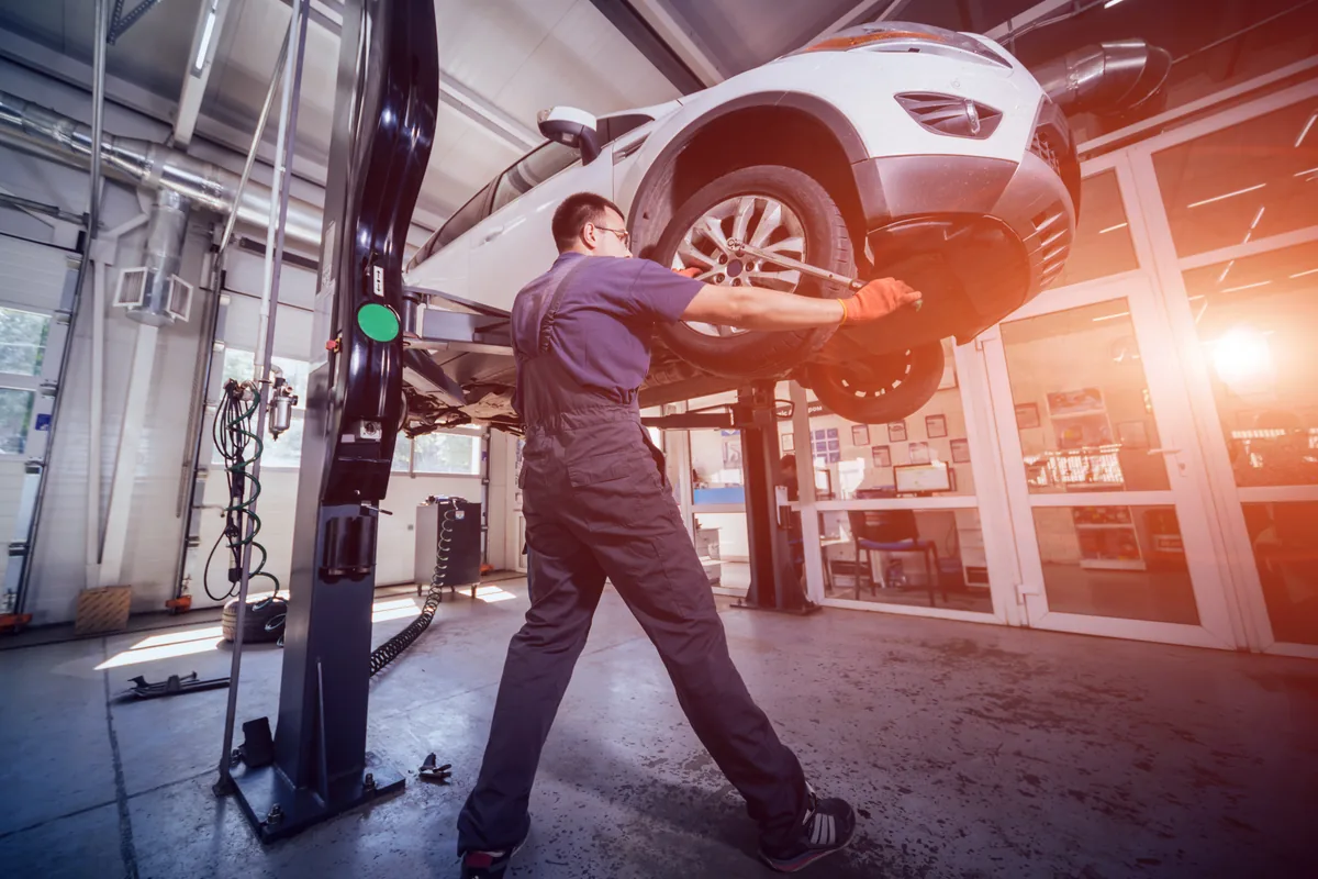 Car raised on a two-post lift for inspection in the workshop